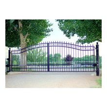 A gate that is open and has trees in the background.