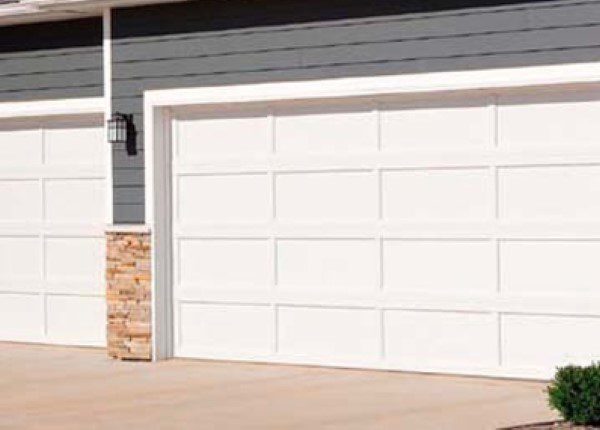 A white garage door sitting in front of a house.