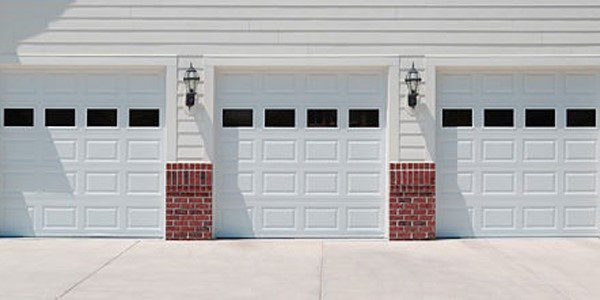 A white garage door with red brick accents.