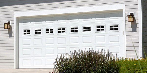 A white garage door with windows on it.