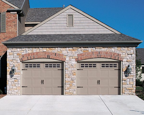 A two car garage with stone walls and brick accents.