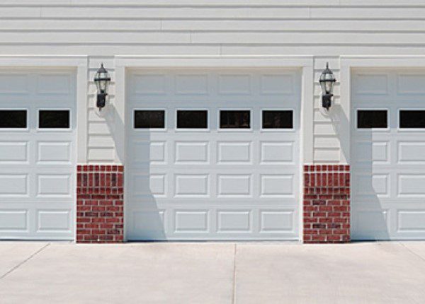 A white garage door with red brick accents.